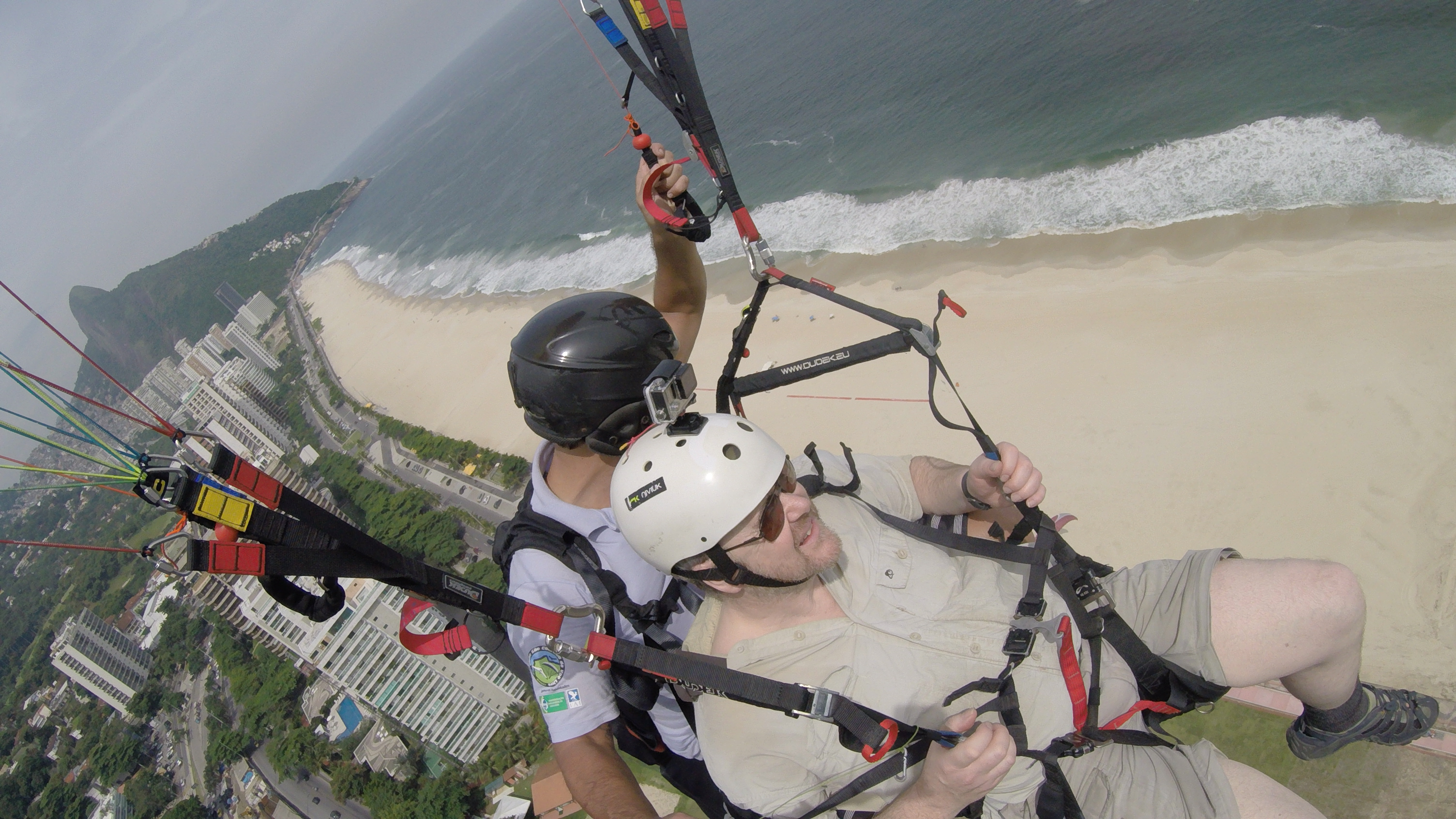 Paragliding above a golden  sandy beach in Rio de Janeiro, Brazil