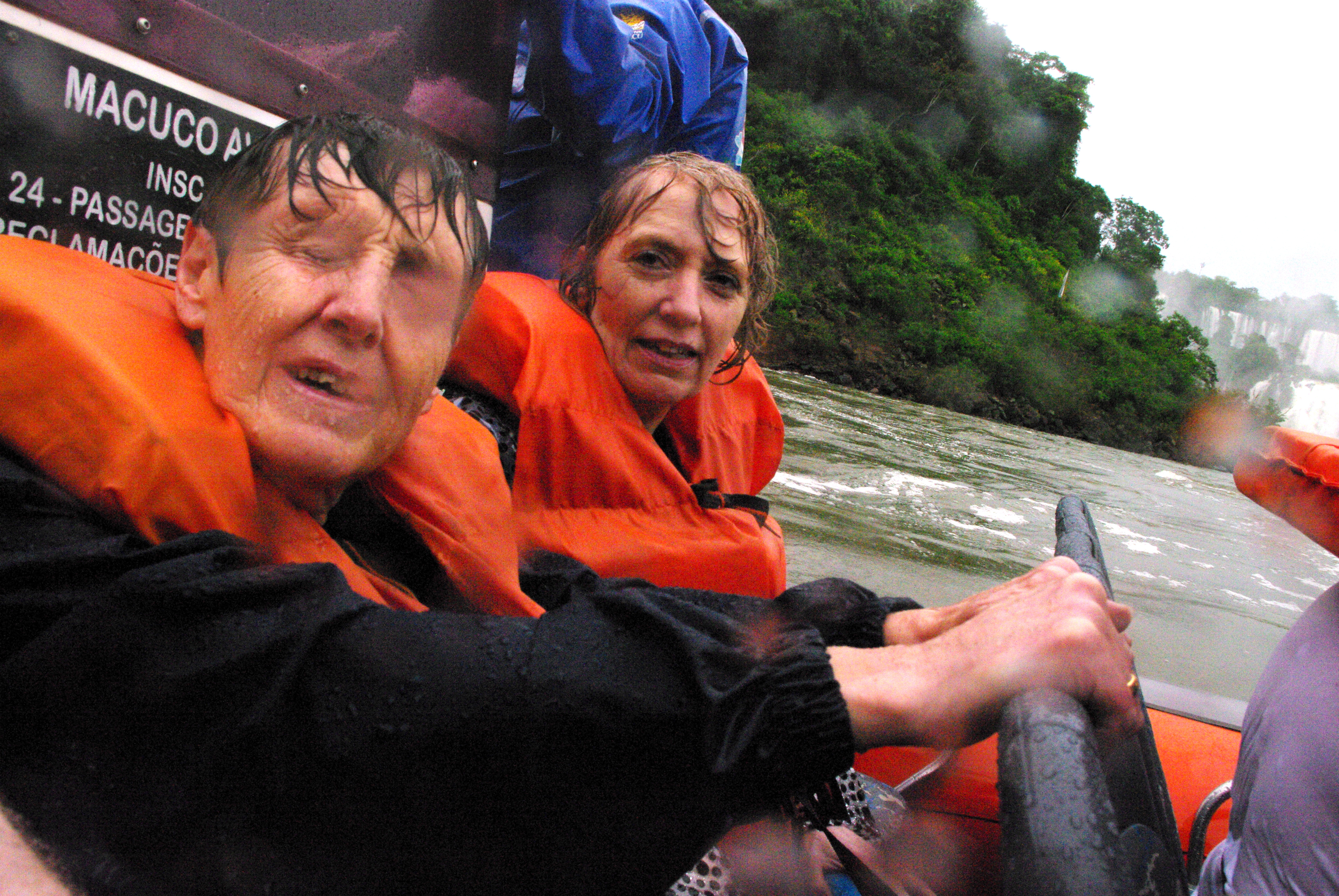 Two of my colleagues sitting in the boat with their life jackets on, looking very wet after our river trip to the falls.