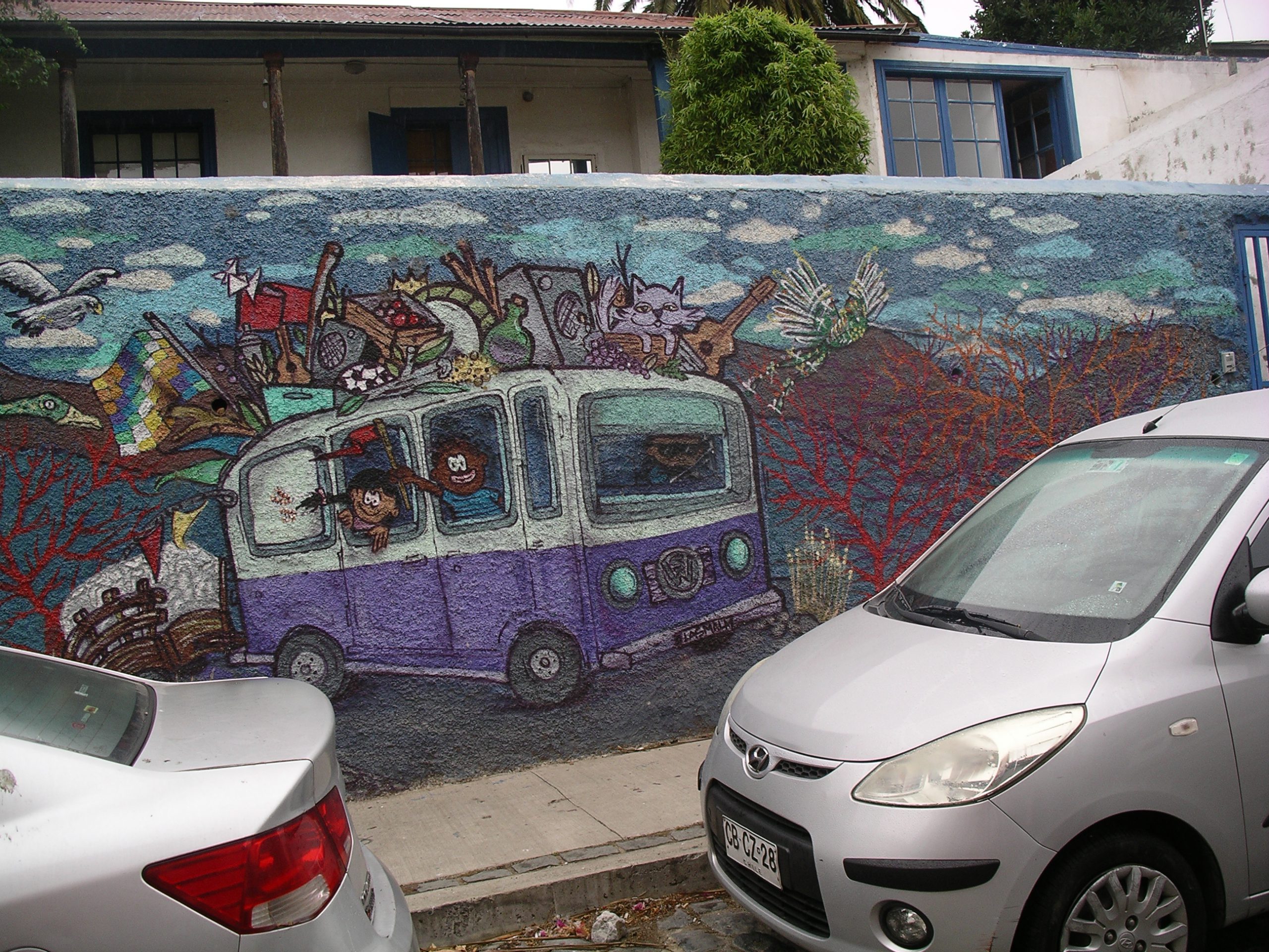 Mural of bus behin parked cars pointed in opposite direction